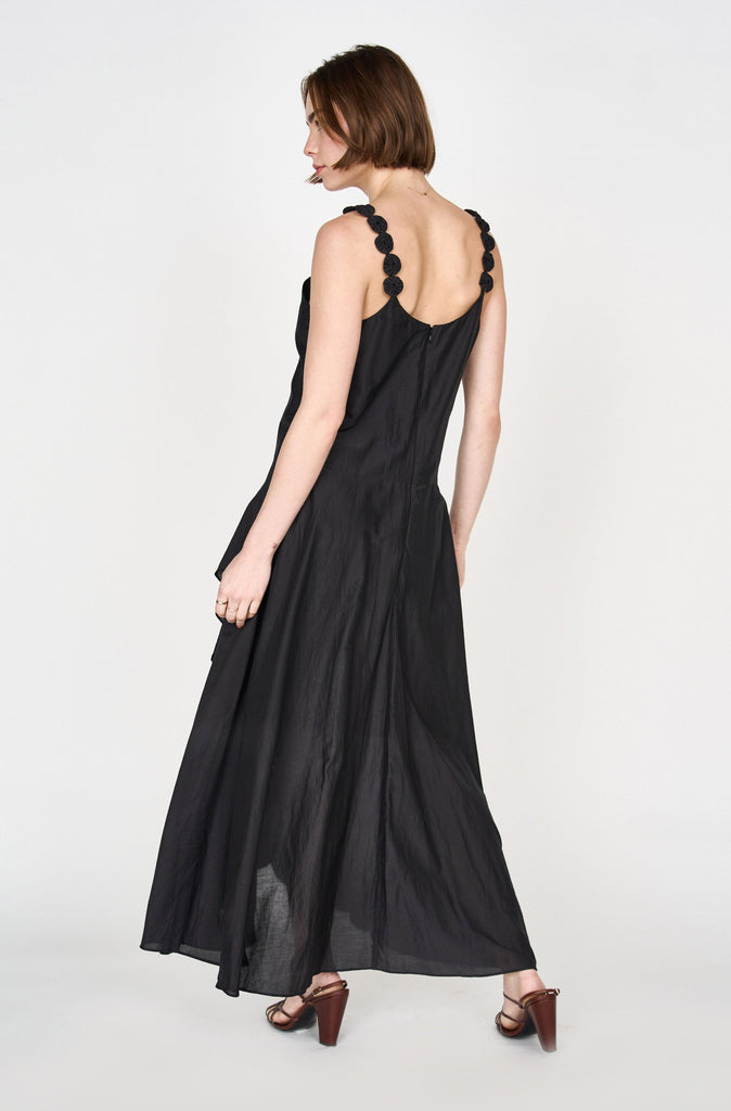 Girl wearing MIRTH women's long singapore spaghetti strap drop waist dress in black cotton silk