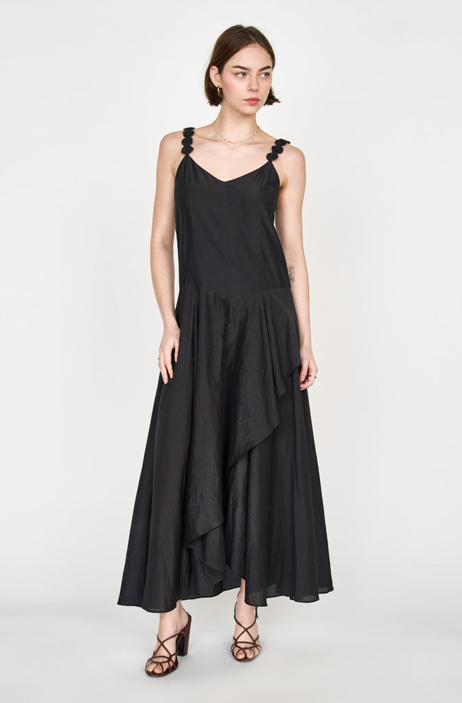 Girl wearing MIRTH women's long singapore spaghetti strap drop waist dress in black cotton silk