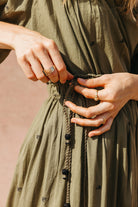 Girl wearing MIRTH women's lowy maxi verona vacation skirt in handloomed jamdani olive green cotton