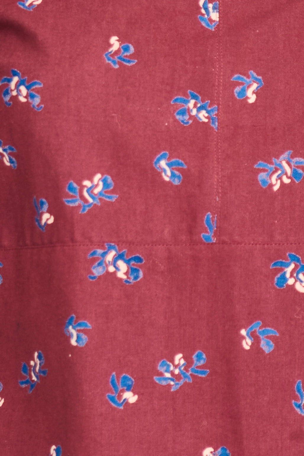 Maroon fabric with small blue and white floral patterns