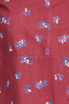 Maroon fabric with small blue and white floral patterns