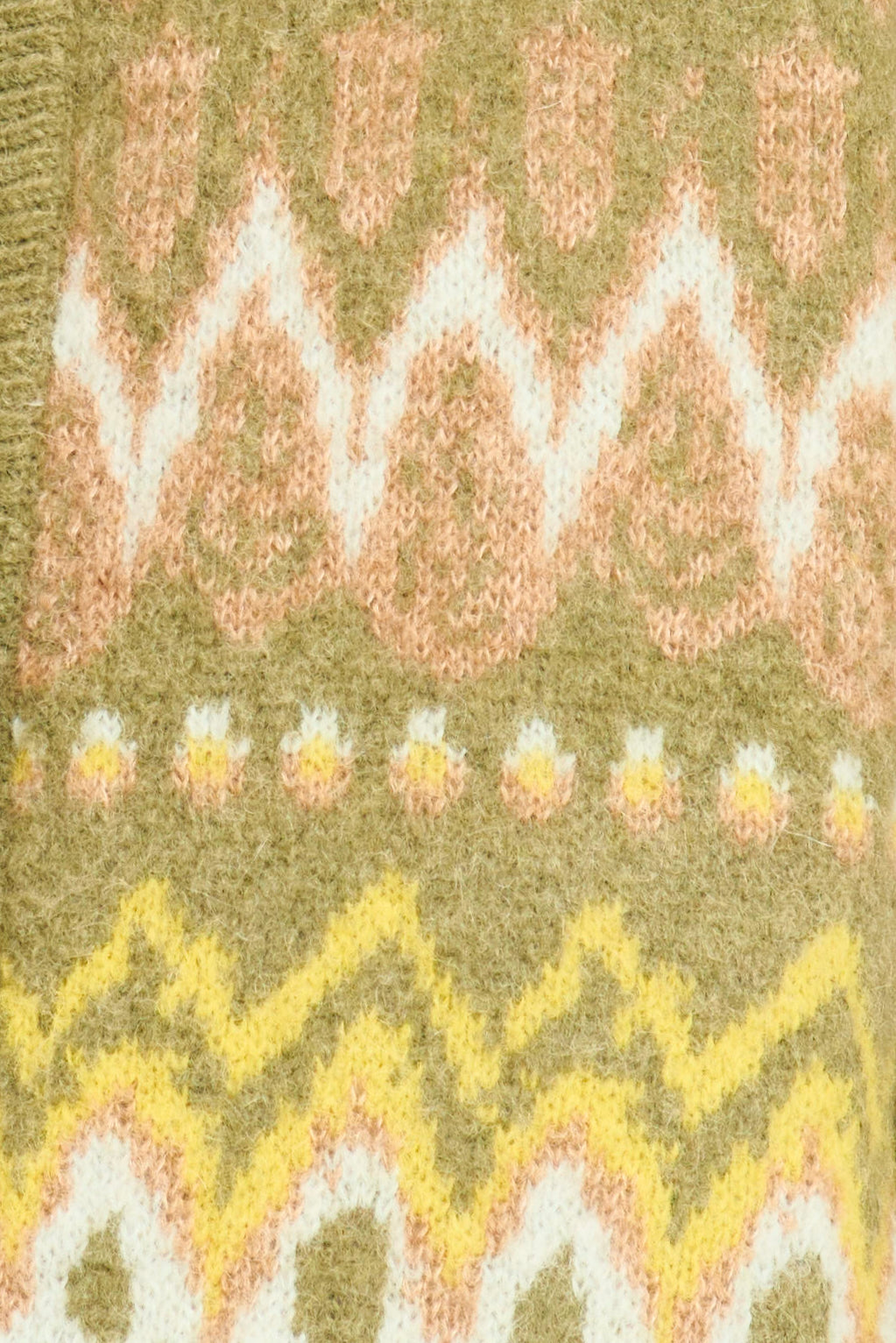 Close-up of a knitted fabric with a pattern featuring wavy lines and small floral elements on a green background.