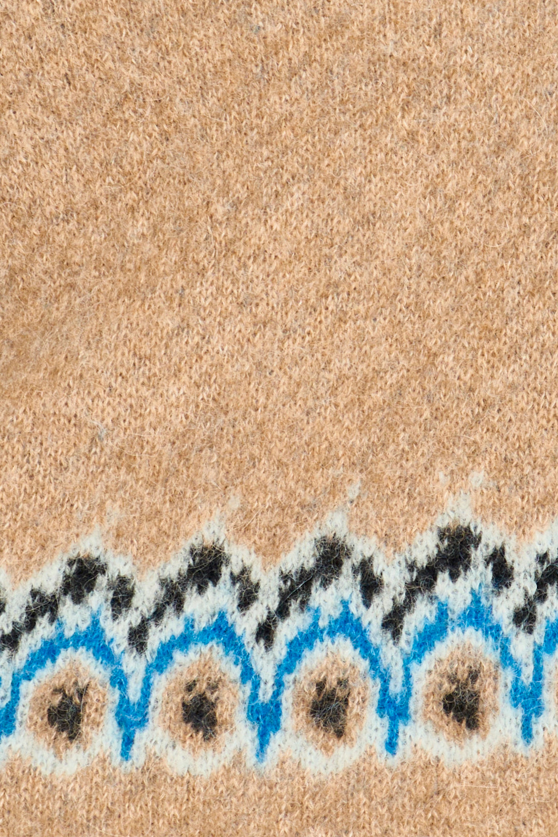 Close-up of a textured beige surface with a decorative border featuring blue and black patterns.