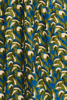 Patterned fabric with blue, green, and white design on a brown background