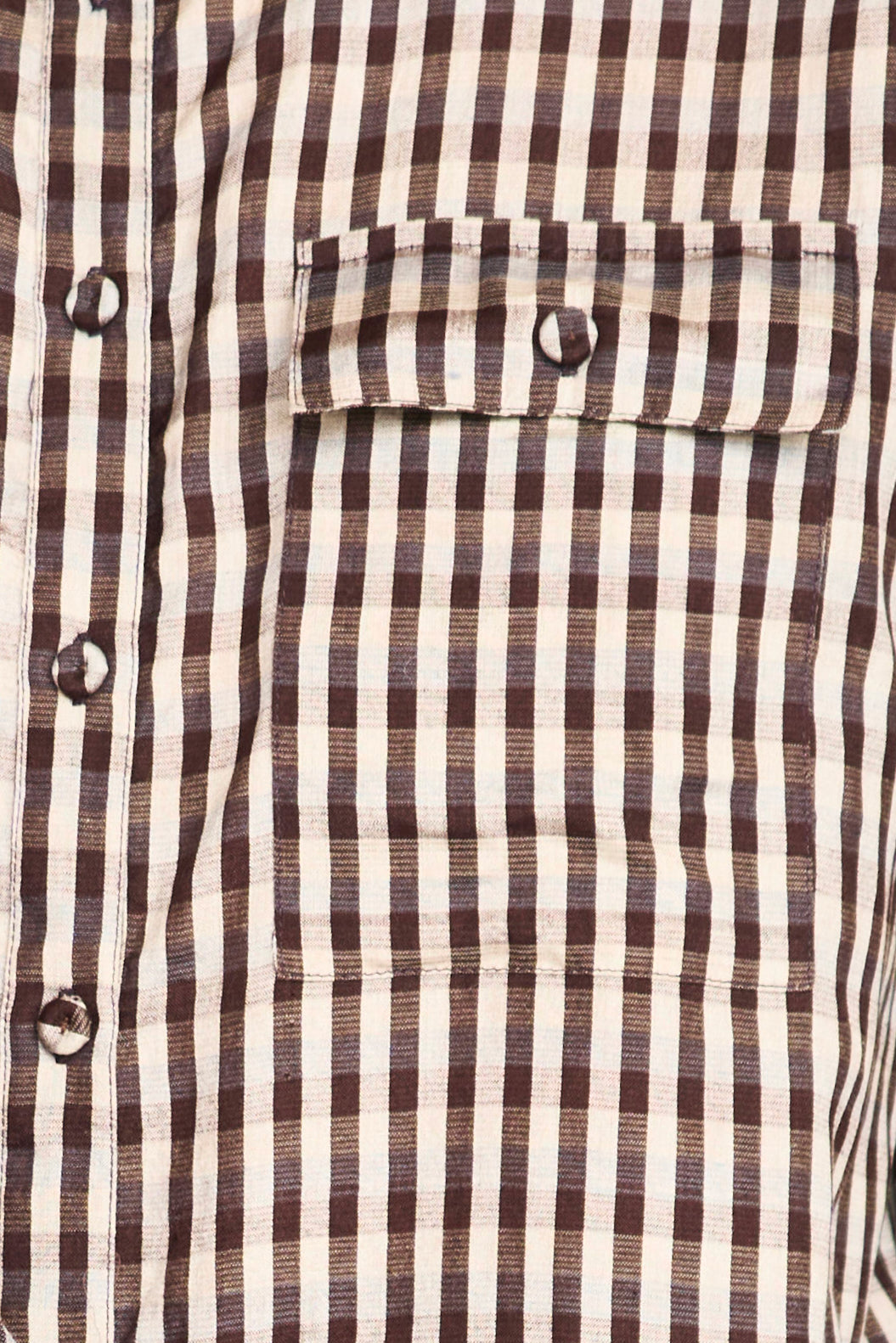 Close-up of a brown and white striped shirt with buttons.