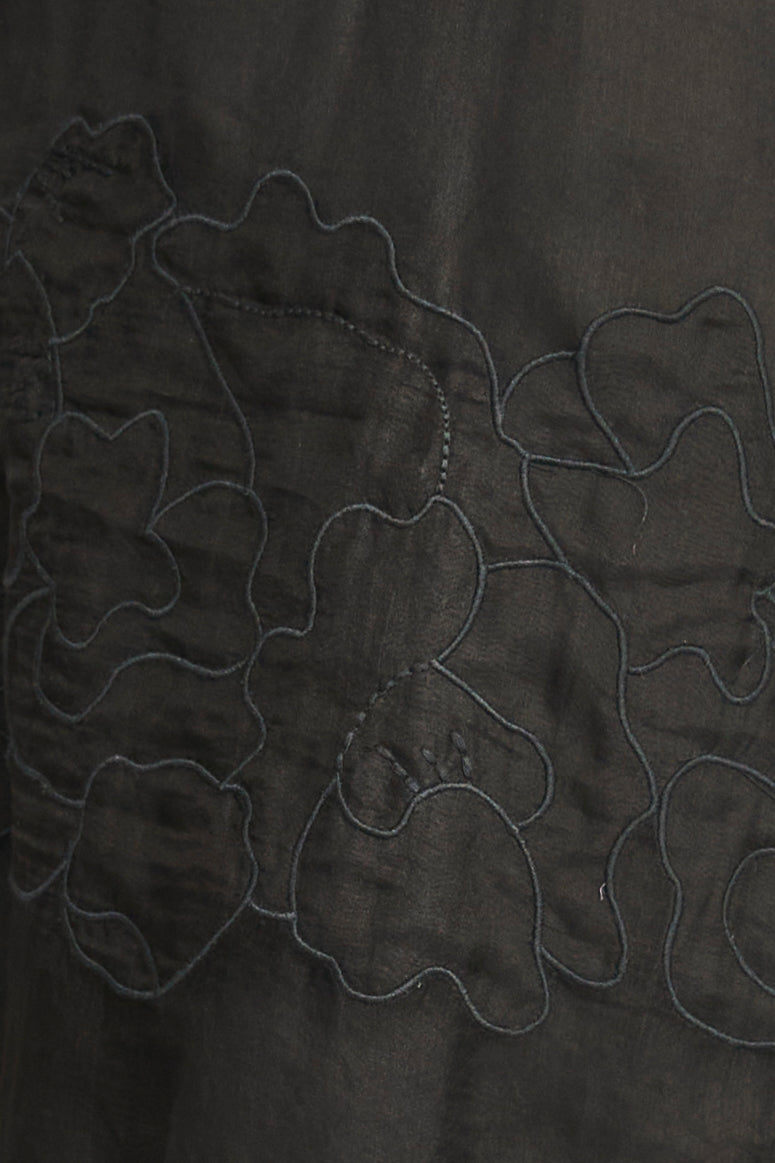 Close-up of dark fabric with embroidered floral patterns
