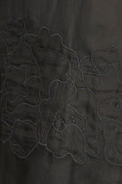 Close-up of dark fabric with embroidered floral patterns