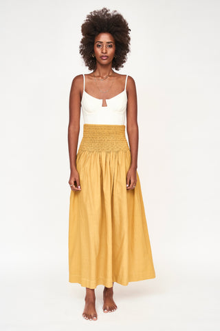 Girl wearing MIRTH women's smocked elastic waist savannah skirt set in yellow gilded cotton