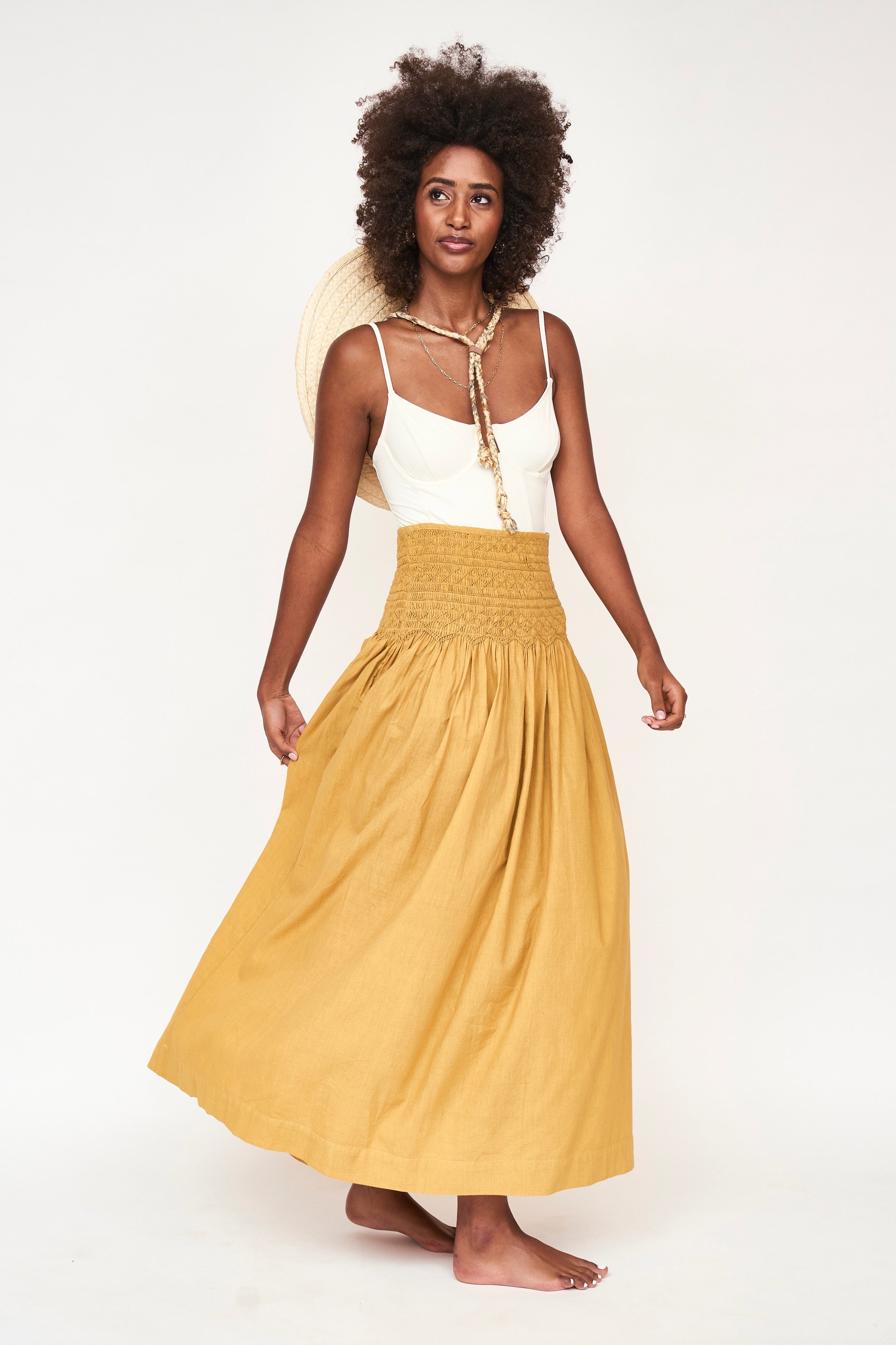 Girl wearing MIRTH women's smocked elastic waist savannah skirt set in yellow gilded cotton