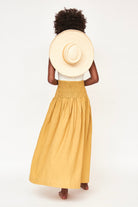 Girl wearing MIRTH women's smocked elastic waist savannah skirt set in yellow gilded cotton