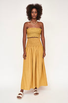 Girl wearing MIRTH women's smocked elastic waist savannah skirt set in yellow gilded cotton