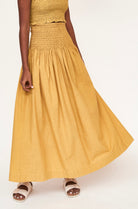 Girl wearing MIRTH women's smocked elastic waist savannah skirt set in yellow gilded cotton