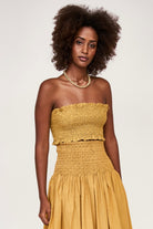 Girl wearing MIRTH women's smocked elastic savannah sleeveless cropped top set in yellow frost cotton