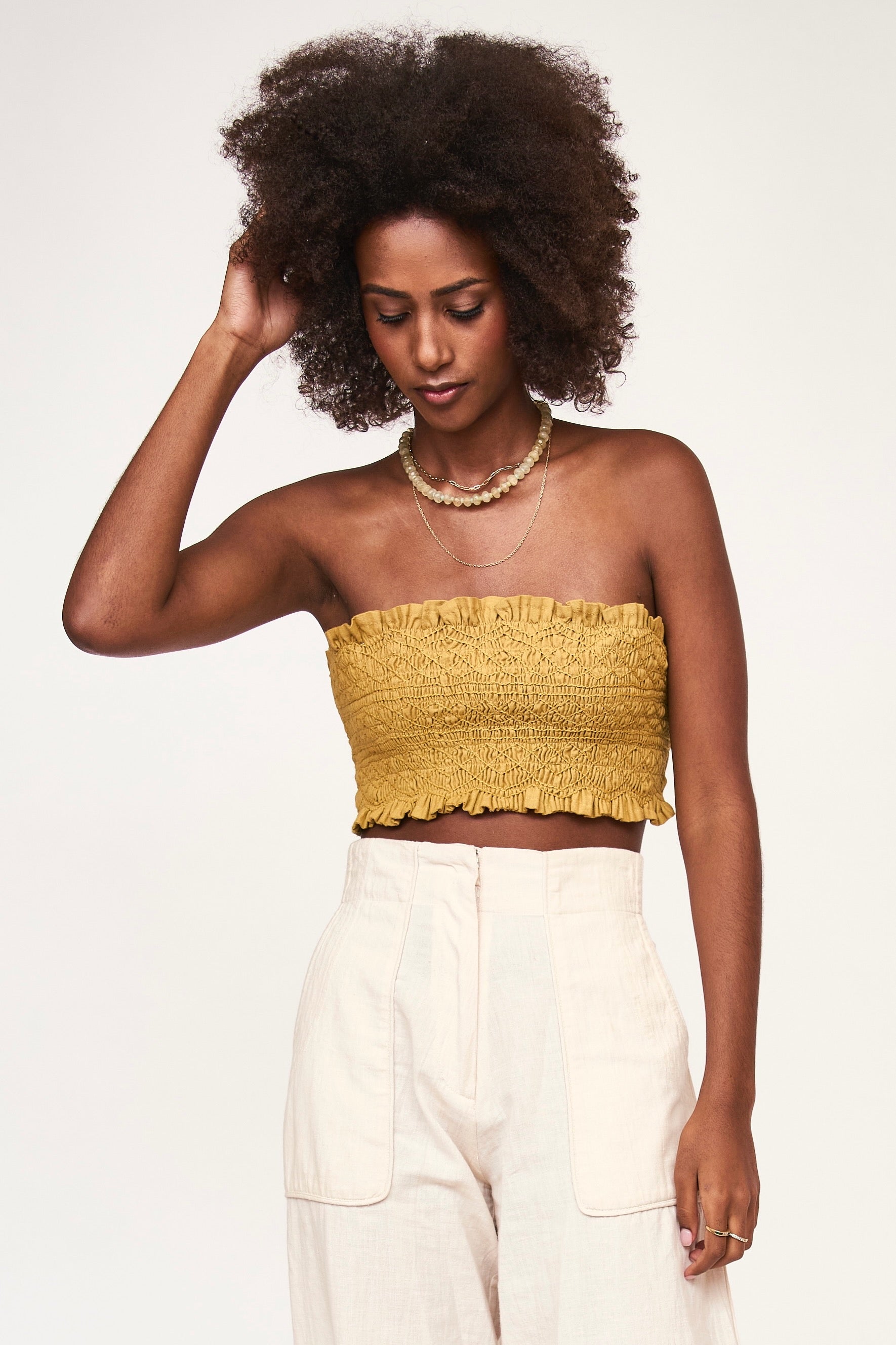 Girl wearing MIRTH women's smocked elastic savannah sleeveless cropped top set in yellow frost cotton