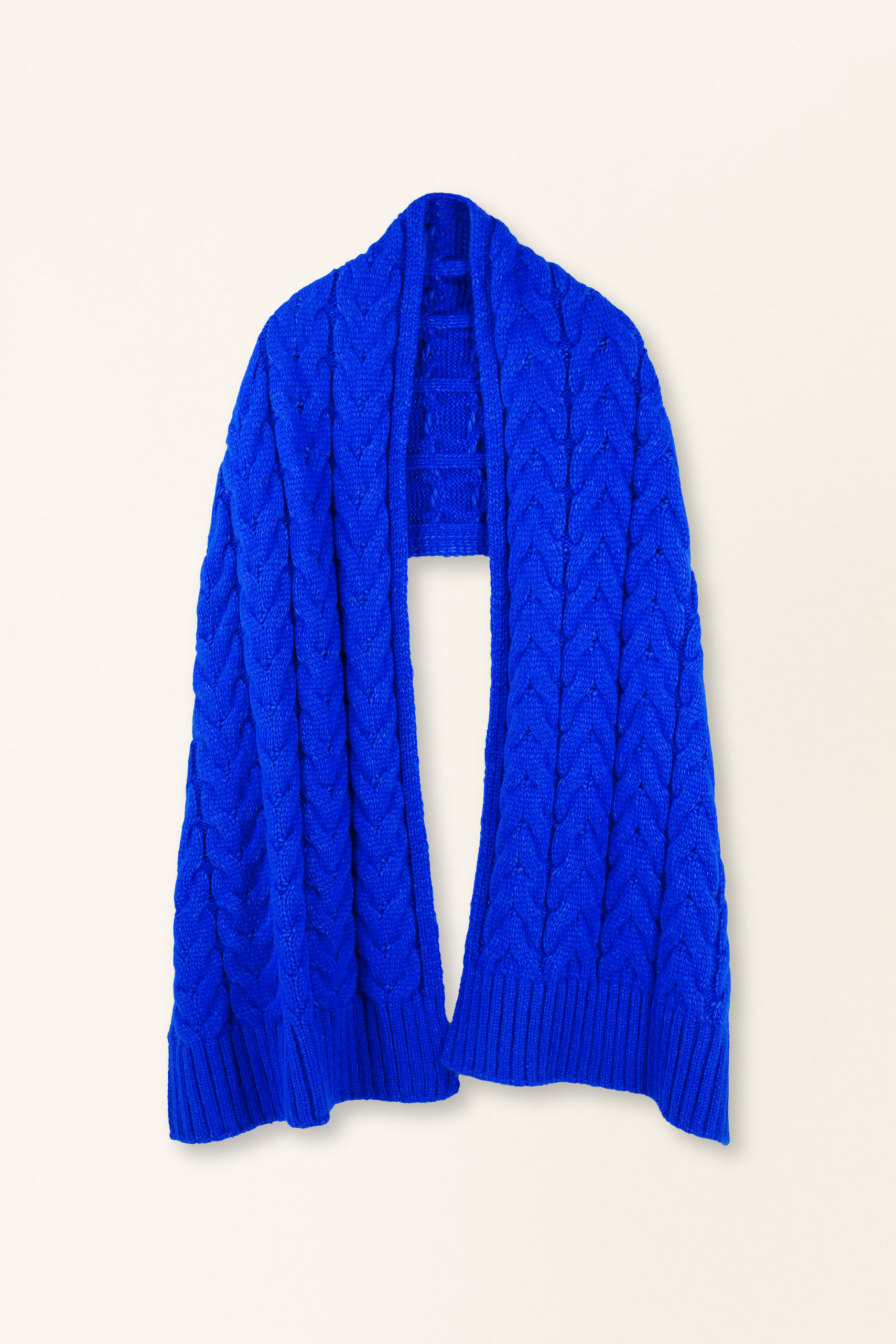 Blue cable knit scarf on a beige background