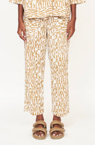 Girl wearing MIRTH women's high waist tailored resort tivot pant in driftwood brown print cotton