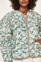 Girl wearing MIRTH women's front zip quilted turin jacket in plumeria blue floral print cotton silk