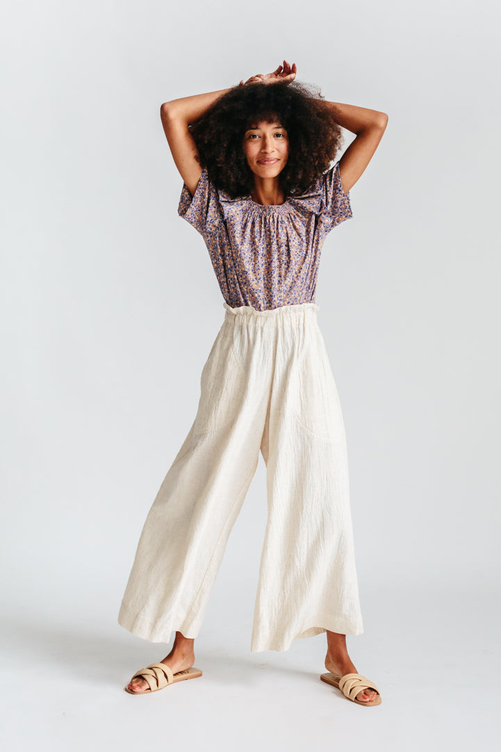 Girl wearing MIRTH women's paperbag waist wide leg palazzo pant in oatmeal beige