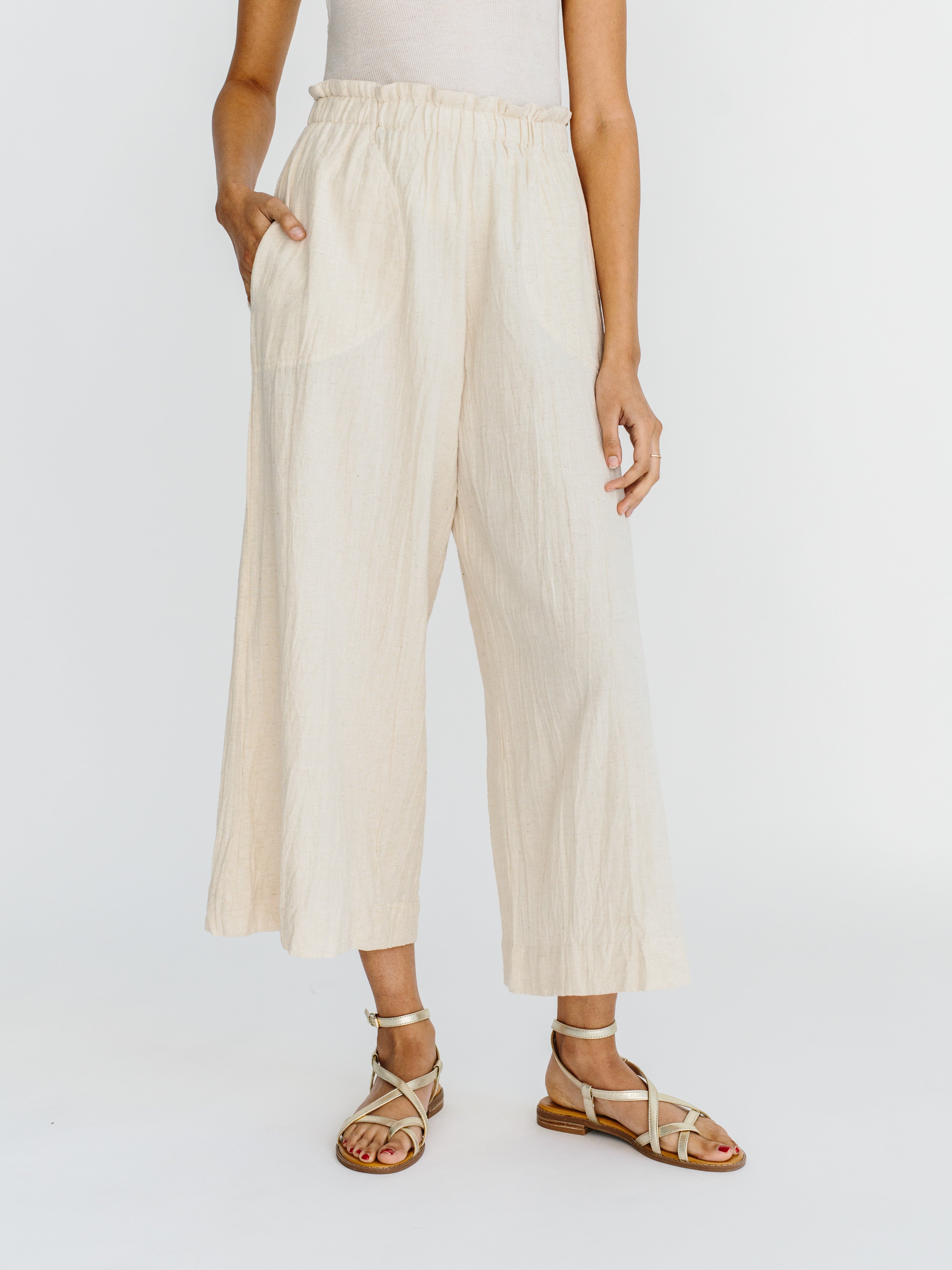 Girl wearing MIRTH women's paperbag waist wide leg palazzo pant in oatmeal beige