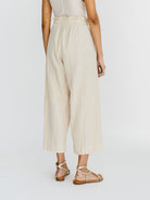 Girl wearing MIRTH women's paperbag waist wide leg palazzo pant in oatmeal beige