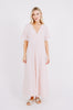 Girl wearing MIRTH women's v-neck tie back bordeaux caftan dress in handloomed light pink rosa cotton jacquard 