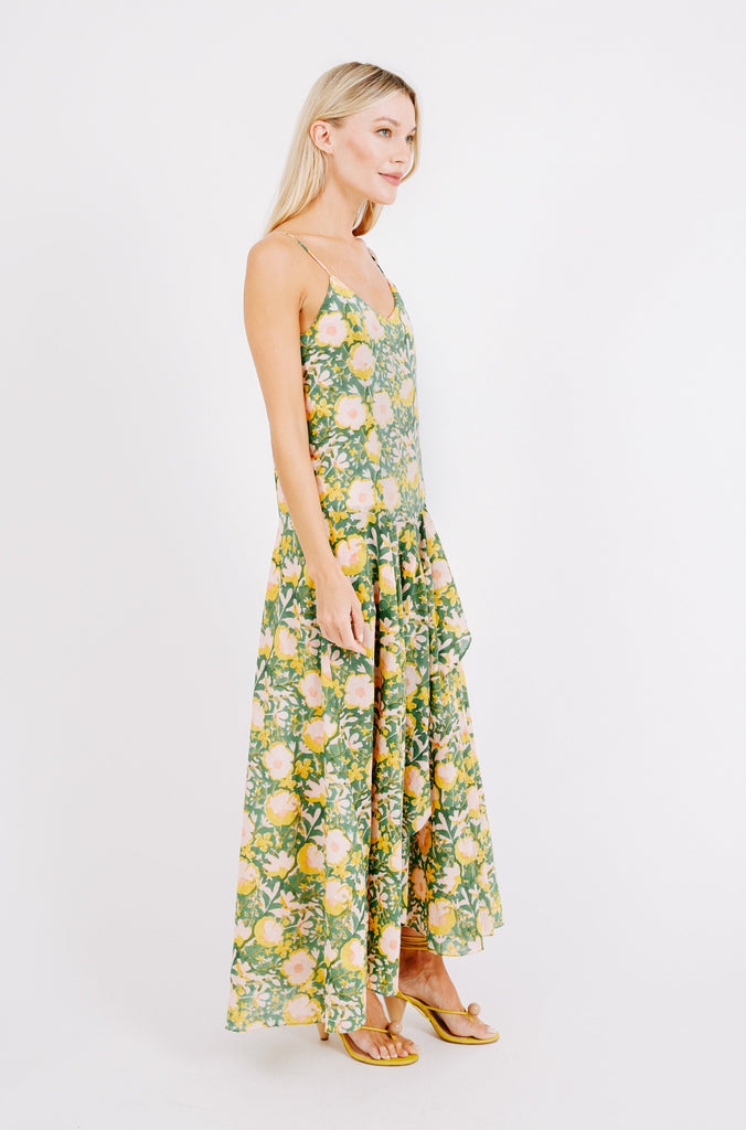 Girl wearing MIRTH women's long singapore spaghetti strap drop waist dress in camelia bloom green floral print cotton