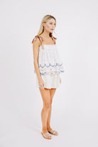 Girl wearing MIRTH women's sleeveless mykonos top with scalloped tie straps in white carnival handloomed cotton jamdani