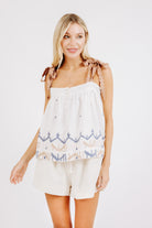 Girl wearing MIRTH women's sleeveless mykonos top with scalloped tie straps in white carnival handloomed cotton jamdani