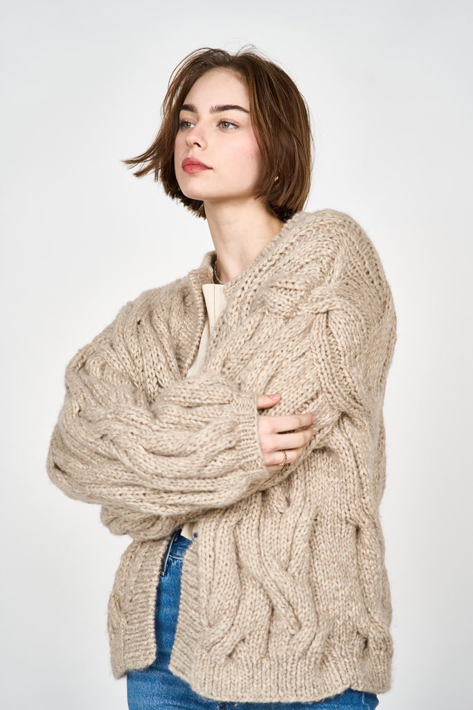 Girl wearing MIRTH women's handknit cortina cable cardigan sweater in camel brown wool