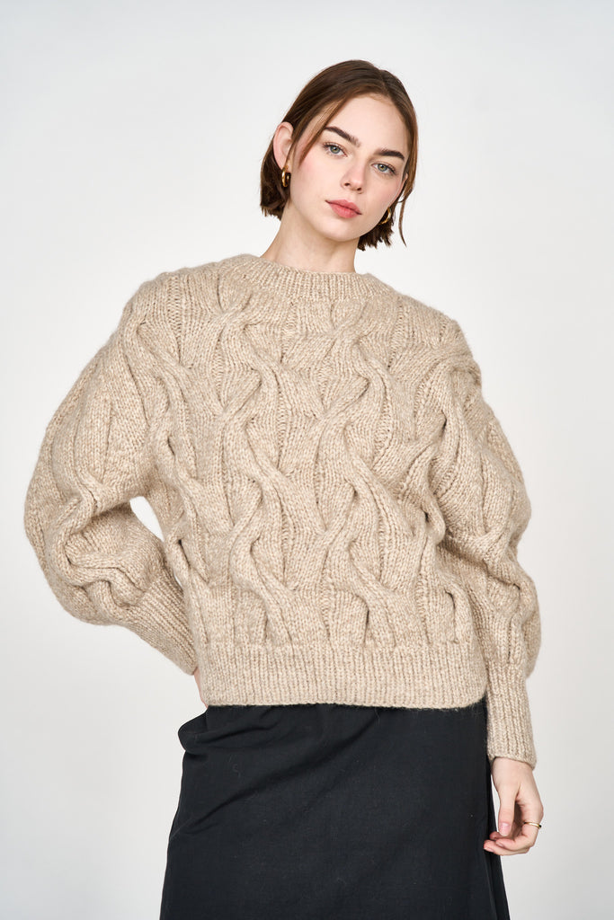 Girl wearing MIRTH women's handknit cortina cable pullover sweater in camel brown wool