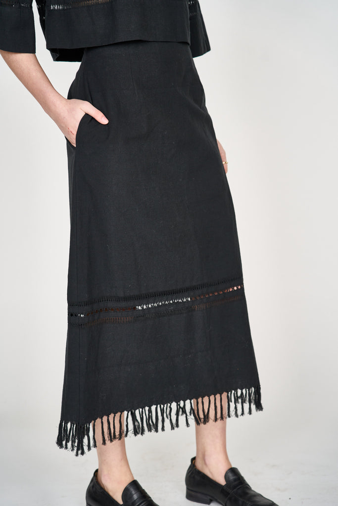 Girl wearing MIRTH women's midi fringe cutout lombok skirt in black cotton