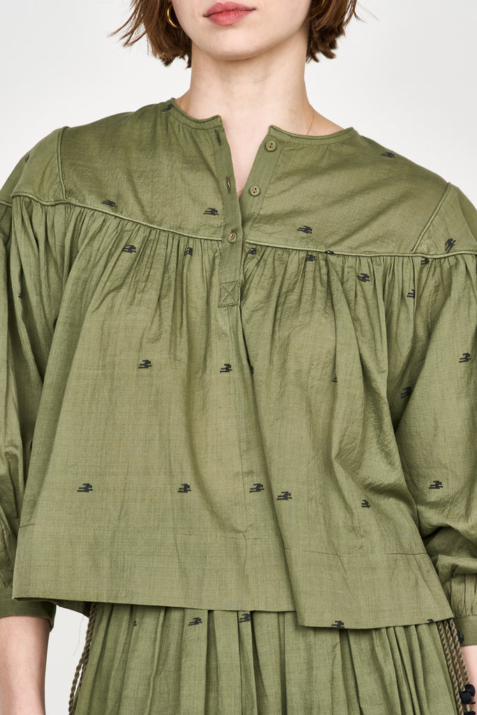 Girl wearing MIRTH women's puff sleeve pullover oslo blouse in handloomed jamadani olive green cotton