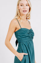 Girl wearing MIRTH women's tie back cutout deia midi sundress in spruce green poplin