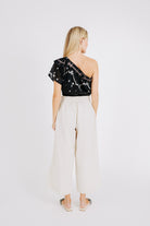 Girl wearing MIRTH women's cropped one shoulder paros top set in handloomed black carnival jamdani