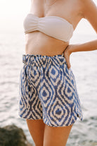 Girl wearing MIRTH women's wide leg elastic waist track shorts in azure ikat blue cotton