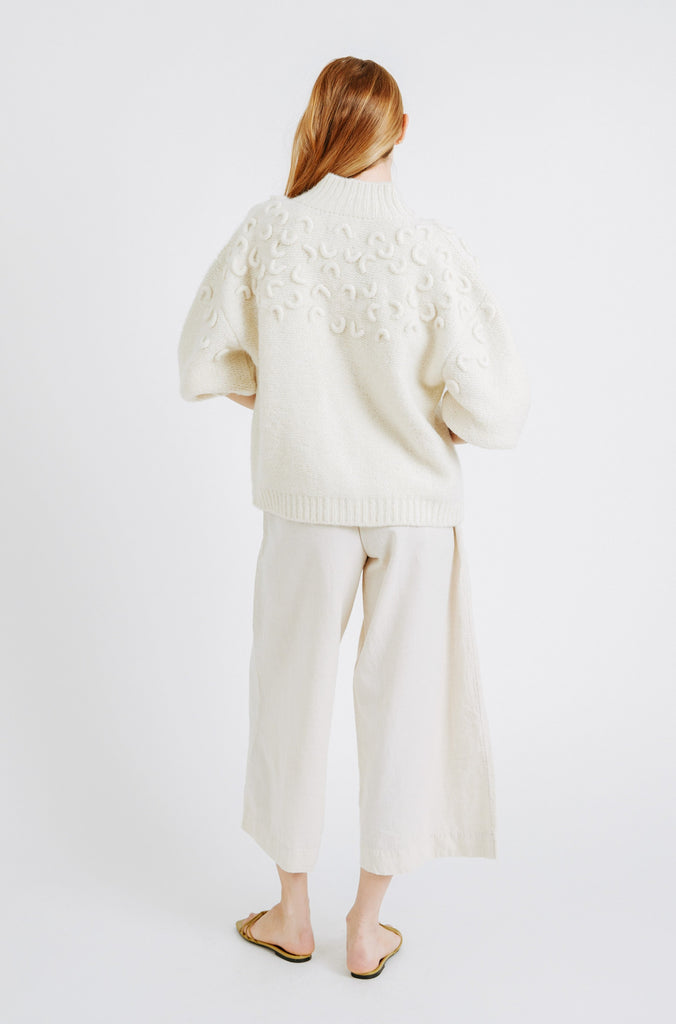 Girl wearing MIRTH women's knit cusco cardigan sweater in ivory white wool