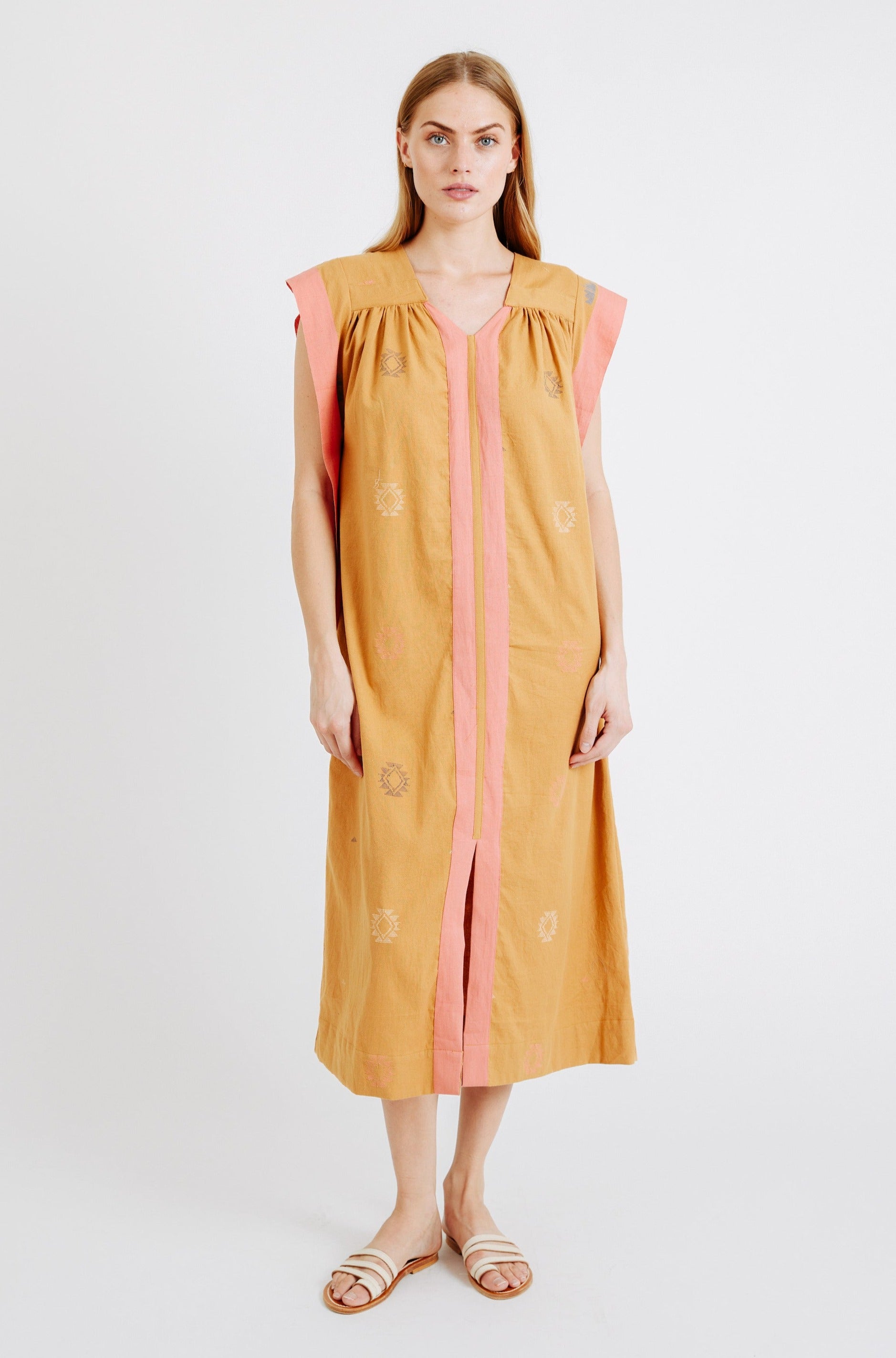 Girl wearing MIRTH women's long pueblo caftan dress in handloomed sedona orange jamdani cotton