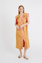 Girl wearing MIRTH women's long pueblo caftan dress in handloomed sedona orange jamdani cotton