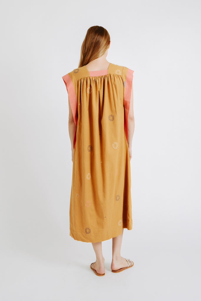 Girl wearing MIRTH women's long pueblo caftan dress in handloomed sedona orange jamdani cotton
