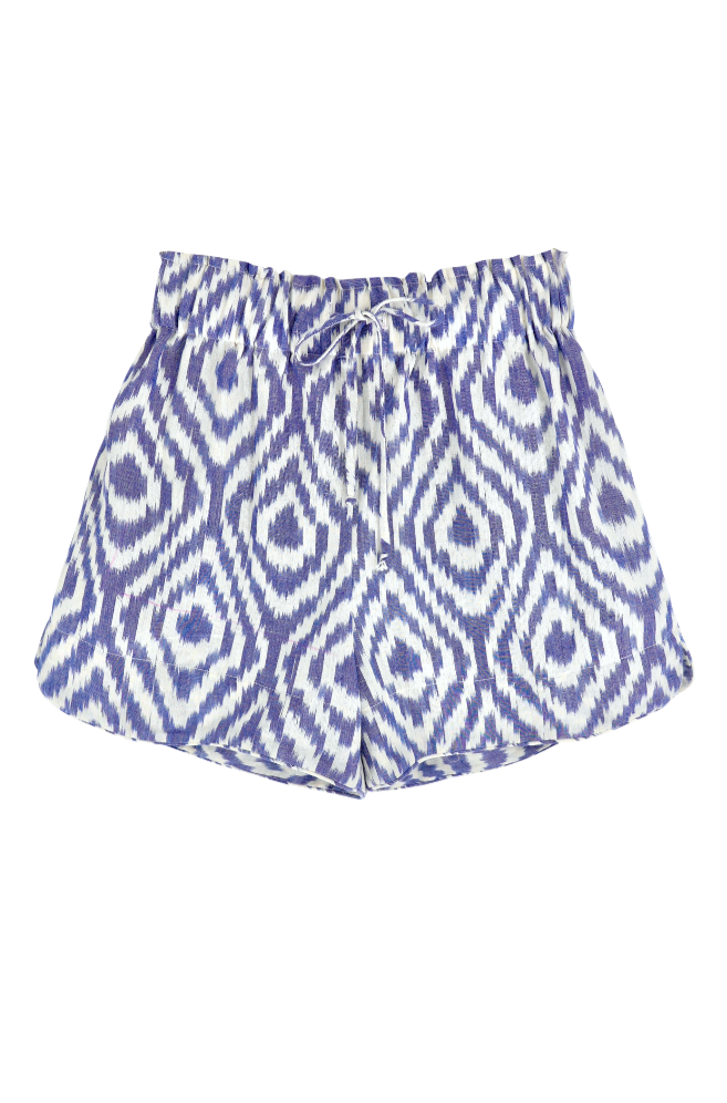 Girl wearing MIRTH women's wide leg elastic waist track shorts in azure ikat blue cotton