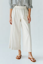 Girl wearing MIRTH women's paperbag waist wide leg palazzo pant in oatmeal beige