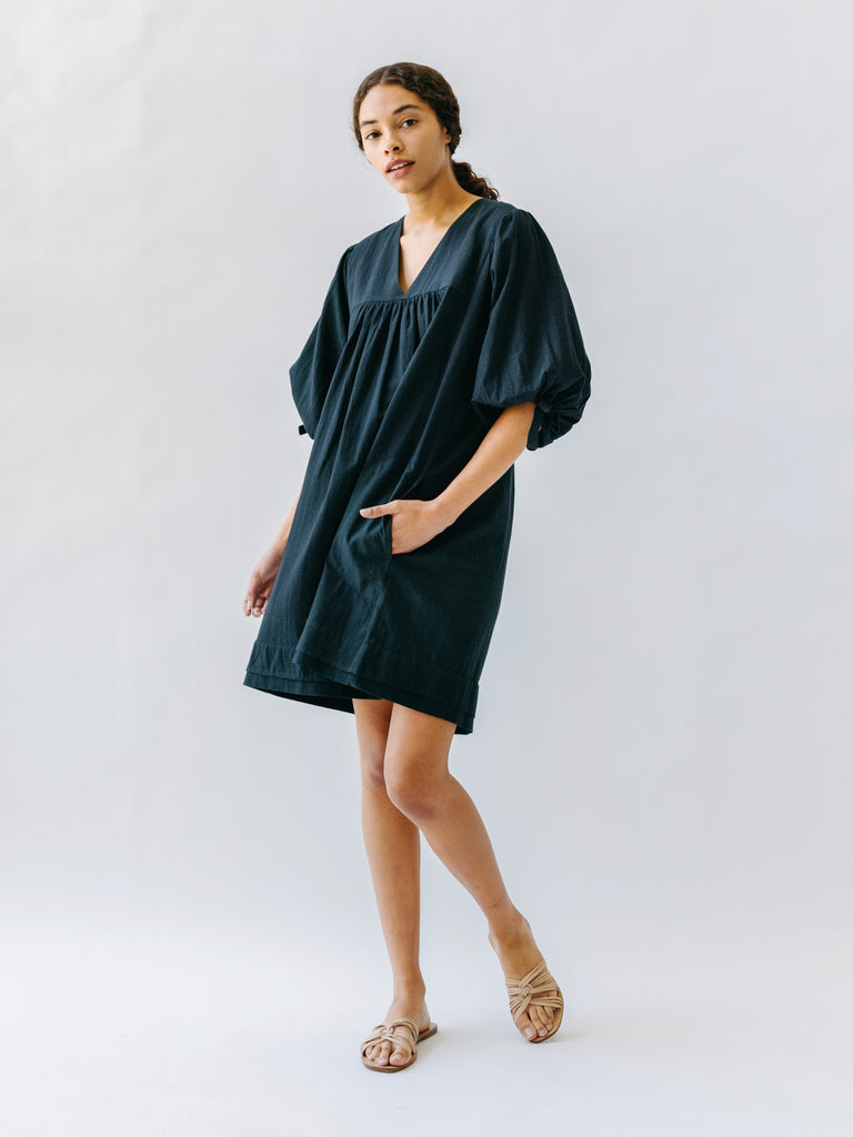 Girl wearing MIRTH women's balloon sleeve short" belem" vacation dress and coverup in black cotton