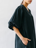 Girl wearing MIRTH women's balloon sleeve short" belem" vacation dress and coverup in black cotton