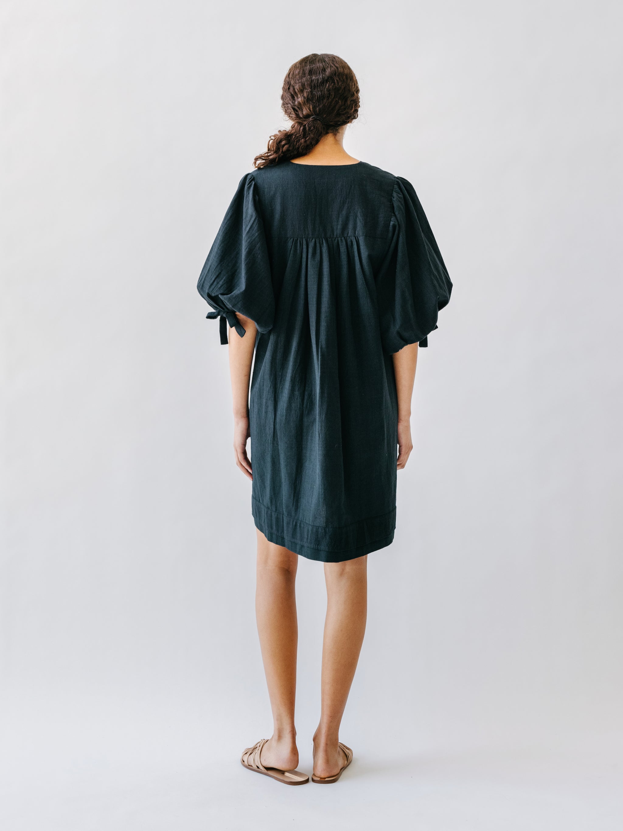 Girl wearing MIRTH women's balloon sleeve short" belem" vacation dress and coverup in black cotton