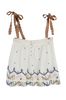 Girl wearing MIRTH women's sleeveless mykonos top with scalloped tie straps in white carnival handloomed cotton jamdani